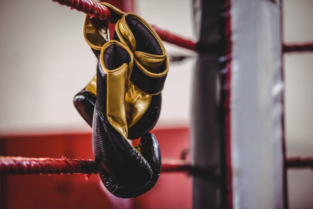 Yellow boxing gloves hanging off the boxing ring